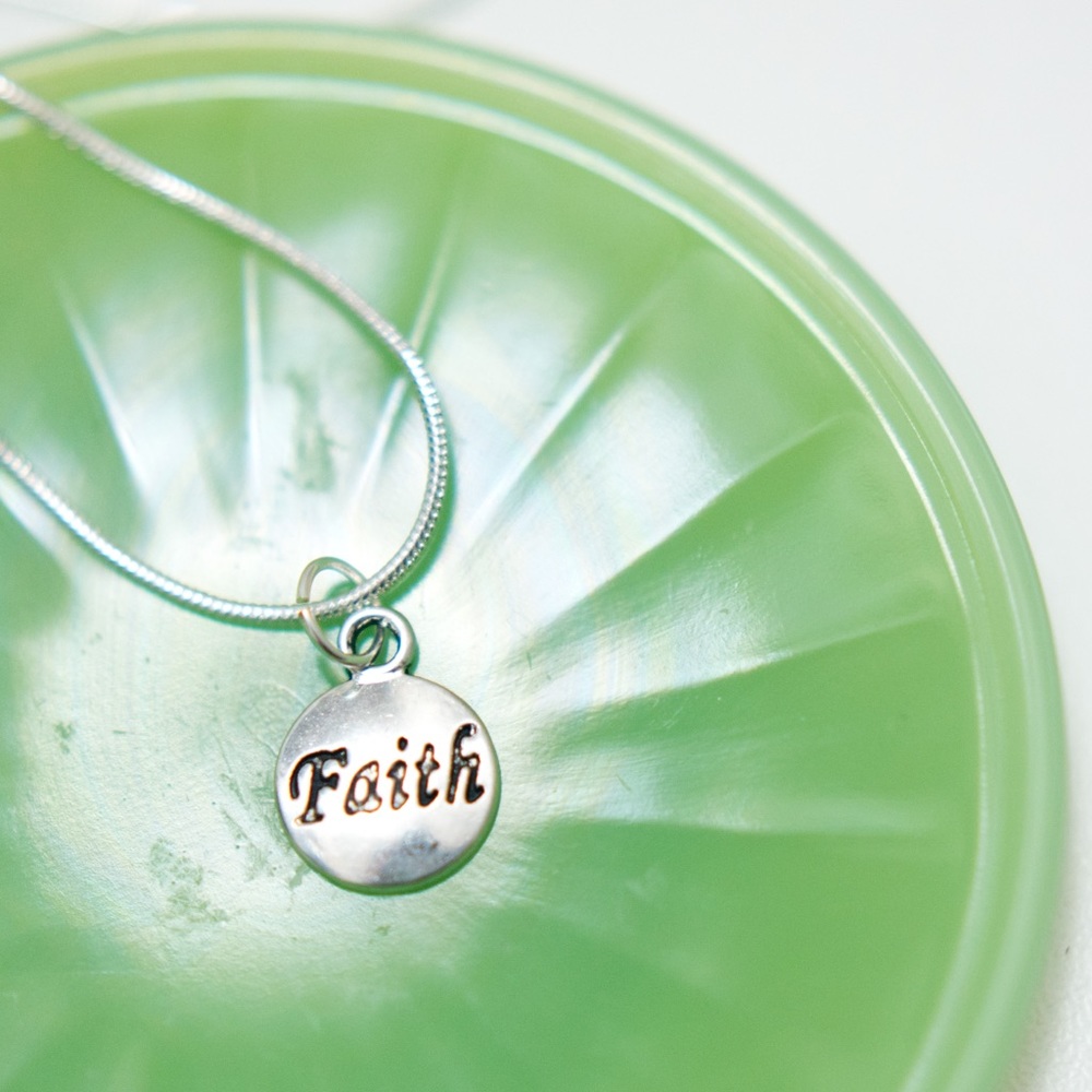 22 inch silver necklace with charm that says faith
